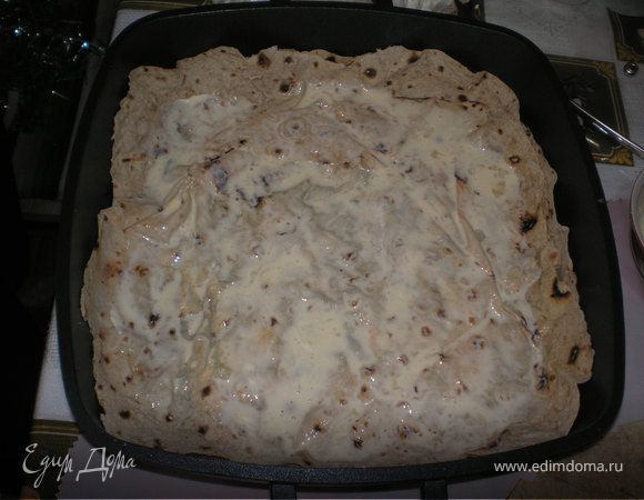 Смазать сковороду растительным маслом.Положить на дно первый лаваш и смазать его смесью яйца и майонеза.