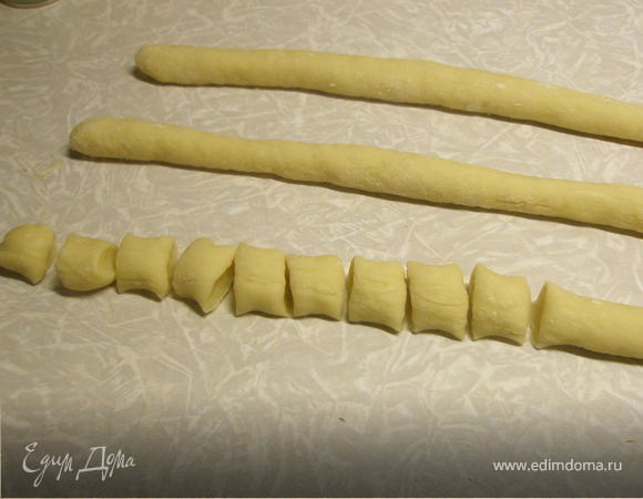 Понемногу вводить просеянную муку. Замесит тесто, оно должно быть мягким.
Сформировать колбаски и нарезать на небольшие кусочки.