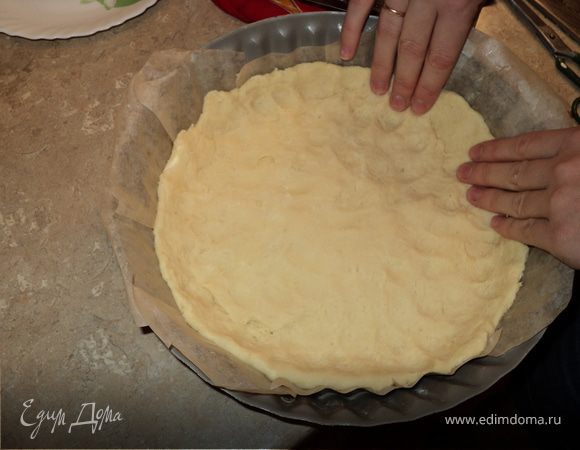 Остужаем начинку. Разогреваем духовку до 180 градусов. Форму выстилаем бумагой для выпечки, смазываем маслом и выкладываем тесто, руками формируя бортик