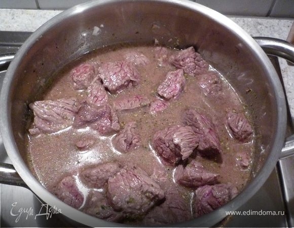 Посыпать мукой, добавить пропущенный через пресс чеснок. Приправить солью, перцем, майораном, тмином. Добавить 250мл воды и вскипятить. Добавить лук. Тушить на медленном огне 90 минут. 