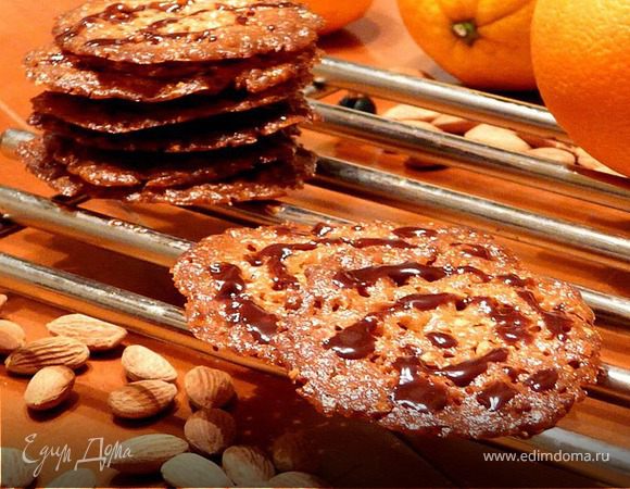 Печь 9-10 минут, шарики станут плоскими печеньями, потемнеют и в них обазуются дырочки. Вынуть деко. Подождать пару минут, лопаткой перенести на решетку и остудить (сначала они будут мягкими).
Повторить с оставшимся тестом.
Растопить шоколад и сделать узоры или слепить шоколадом по 2 штуки.
