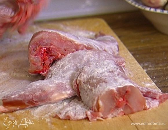 На разделочную доску насыпать муку, добавить по щепотке соли и свежемолотого черного перца, все перемешать, а затем хорошенько обвалять в этой смеси куски кролика.