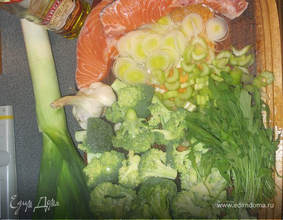 Чеснок крупно порубить,лук нарезать кольцами,сельдерей на кусочки,  капусту разобрать на соцветия. В кастрюле разогреть масло быстро обжарить чеснок, лук и сельдерей. Добавить руколу, сверху положить рыбу, затем капусту. Залить водой так, чтобы она не покрывала капусту, добавить лавровый лист, все посолить и поперчить.
