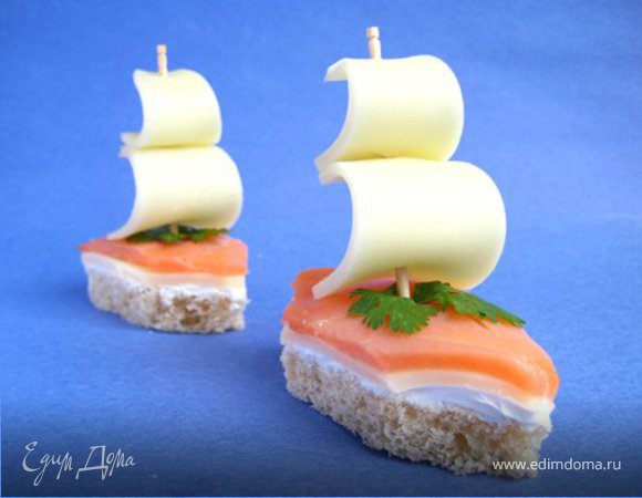 Орехи измельчить и смешать с творогом, добавить соль. Из этой массы сделать шарики. Затем отдельно протереть (крупно) крабовые палочки. Готовые шарики обвалять в протёртых крабовых палочках. Разложить зелёный салат на плоскую тарелку, на которую положить обваленные шарики. Можно украсить маслинами, как показано на картинке. Но также можно на каждую маслинку воткнуть "парусник" из ветчины. Будет выглядеть как на приложенной картинке. ПРИЯТНОГО АППЕТИТА!