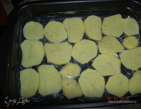 Форму для запекания смазать маслом, выложить половину картофеля, немного посолить.
