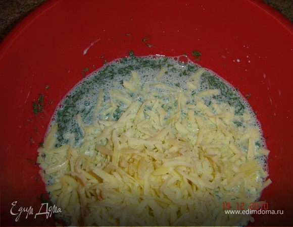 Сыр натереть на средней терке. Яйца немного взбить, добавить молоко, зелень и сыр.