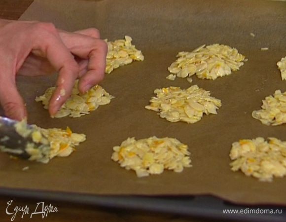 Выстелить противень бумагой для выпечки, смазанной маслом, и на большом расстоянии друг от друга ложкой выложить на бумагу небольшие печеньица, слегка расплющив их.