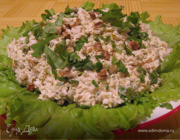 Листья салата разложить на тарелку, на них выложить салат, посыпать петрушкой и орехами.