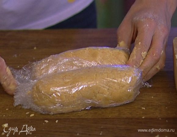 Предварительно размягченное сливочное масло и сыр добавить к муке и вымешать тесто, затем разделить его пополам, сформировать две колбаски диаметром 5–8 см, завернуть их в пищевую пленку и отправить в холодильник на 30 минут.