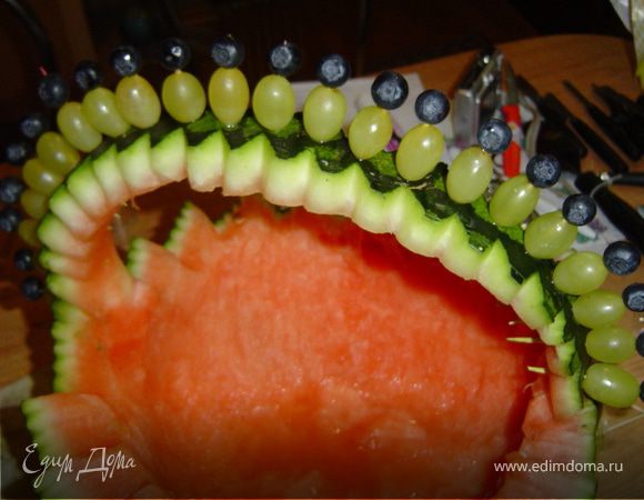 Ложкой выбираем мякоть арбуза. Ручку украшаем виноградом и черникой, насаживая их на зубочистки.