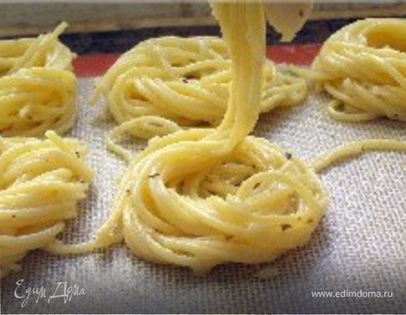 На противень положить промасленную бумагу для выпечки Выложить спагетти придав им круглую форму диаметром 6-7 см.