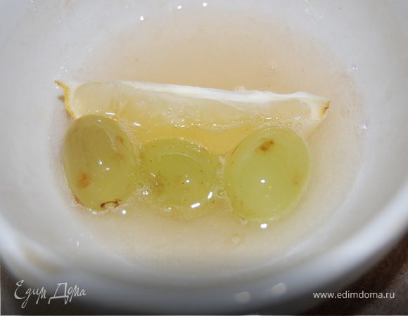 Теперь займемся фруктами в снегу. Заливаем желатин водой и оставляем на 30 минут, затем разогреваем, но не даем закипеть. Виноградины, лимон вымыть и вытереть насухо. От лимона отрезали симпатичную дольку, вместе с цедрой. Можно так же поступить с мандаринами, яблоками (только дольку яблока надо сбрызнуть лимонным соком, чтоб не потемнела, кожицу оставить, а сердцевинку удалить) и вообще с любыми сезонными ягодами и фруктами. Опускаем фрукты в желатин, надо  чтоб желатином была покрыта вся поверхность плода. 