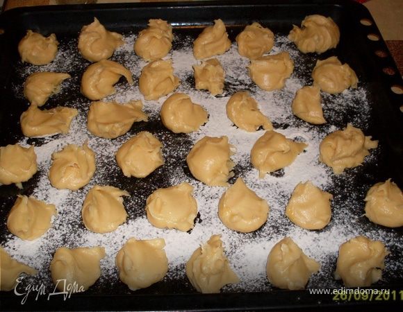 Кладем тесто в кондитерский мешок с насадкой и выдавливаем на противень небольшие шарики размером в яйцо. Можно выкладывать просто ложкой. Расстояние между шариками 2-3см.Они вырастут в размере.