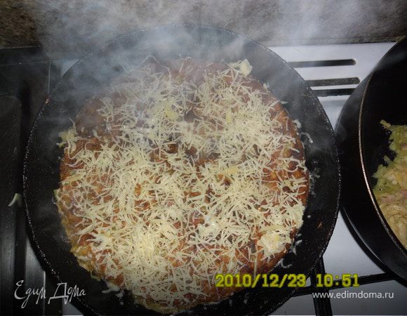 Блин аккуратно перевернуть на другую сторону.Первую посыпать тертым сыром,накрыть крышкой и жарить еще 10 минут.Готовую пиццу украсить майонезом и кетчупом.