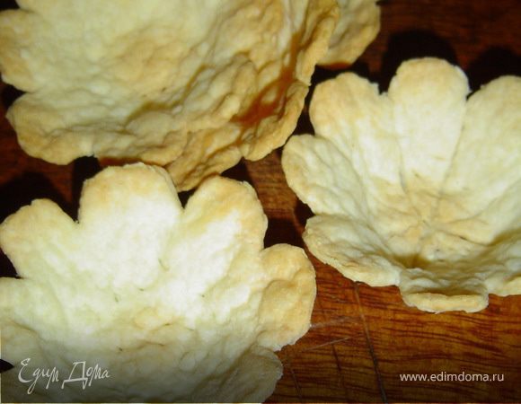 Из готового слоеного теста выпекаем тарталетки, предварительно раскатав тесто, вырезаем кружки (по желанию сделать лепесточки). Кружки размещаем в формочки, смазанные маргарином, прокалываем в нескольких местах и выпекаем при температуре 180 гр. до золотистого цвета.