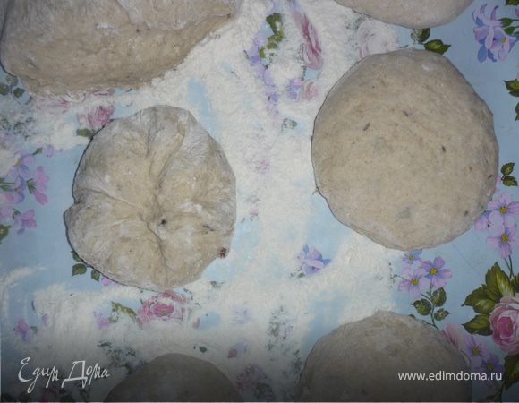 Стол и руки присыпаем мукой, выкладываем тесто и обминаем, разделываем по своему усмотрению, но не мелко. Я делила на 8 равных частей. Каждую часть вымесить и придать форму лепешки. У 4 лепешек  защипнуть края к центру как хинкали,сделать круглые булки  и выложить на противень швом вниз, а из оставшихся скрутить батоны (см. фото внизу). Таким образом сформированный хлеб не будет расползаться по противню и лучше сохранит форму. 