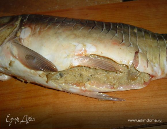 Поперек рыбы делаем надрезы. Заполняем готовым фаршем брюшко рыбы, выкладываем на противень, поливаем растопленным маслом и запекаем в духовке при 170 гр. 25 минут.