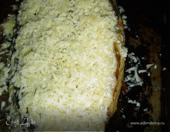 Достаем рыбу из духовки и посыпаем тертым сыром, отправляем в духовку еще на 20 минут.