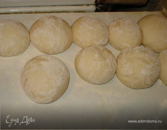 Замесить дрожжевое тесто. Муку смешать с дрожжами, сделать углубление в муке и влить теплую воду, в которой разбавлены соль и сахар. Вымесить упругое тесто и подставить подниматься на 1 час, обмять и еще на 30 минут. После очень тщательно вымесить тесто и разделить его на шарики.