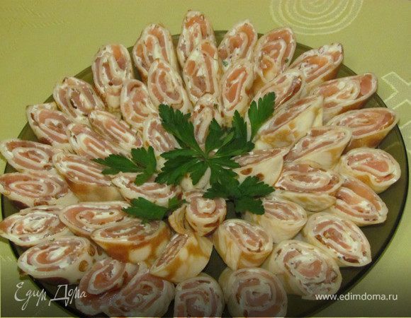 Творожный сыр смешиваем со сметаной, можно добавить зелень и немного чеснока (я брала сыр Венский завтрак с чесноком и зеленью). Когда блинчики остынут, смазываем их творожной смесью. Затем нарезаем тонкими полосками семгу и выкладываем сверху творожной массы. Сворачиваем плотные трубочки и отправляем в холодильник на пару часов. Затем нарезаем и украшаем зеленью. Приятного аппетита!