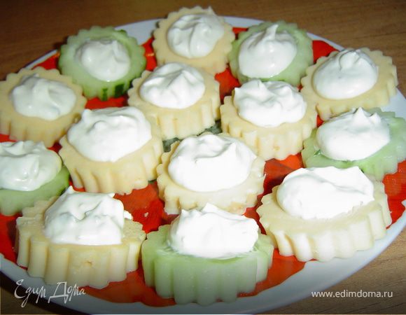 Сырные и огуречные "цветочки" выкладываем на блюдо, а сверху помещаем сливочный сыр.