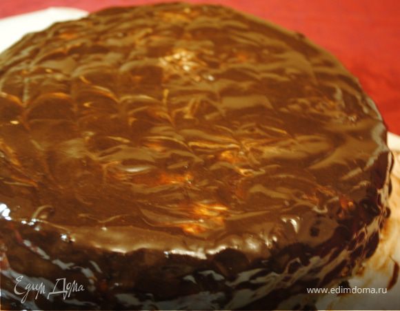 Смешать  размягченное масло с 3 яйцами, 1 банкой сгущенки. Добавить соды, гашеной уксусом. Всыпать просеянную муку.
Затем по рецепту тесто нужно разделить на 2 равных части, в одну из которых добавить какао. Выпекать 2 коржа при температуре 180-190 градусов 15 мин( до готовности).
Я сразу добавила какао в тесто и выпекала его до готовности.
Выпеченные коржи разрезать на 3-4 коржа( это зависит от размеров формы).
Коржи, в том числе и края,смазываем пропиткой из сметаны . Чтобы они лучше пропитались, надо протыкать их вилкой.  Пропитка: сметану смешать сахарной пудрой и цедрой апельсина.
Когда коржи достаточно пропитаются, смазываем их глазурью. Глазурь: все ингредиенты смешать в сотейнике и поставить на огонь, постоянно помешивая. Как только закипит, сразу снять и дать немного загустеть.