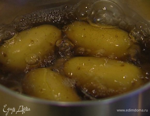 Картофель вымыть и отварить в мундире, затем разрезать на половинки.
