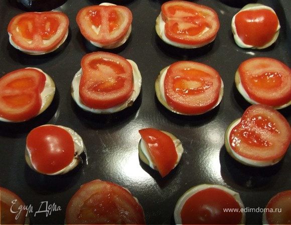 Помидоры нарезаем тонкими кружочками и выкладываем на баклажаны.