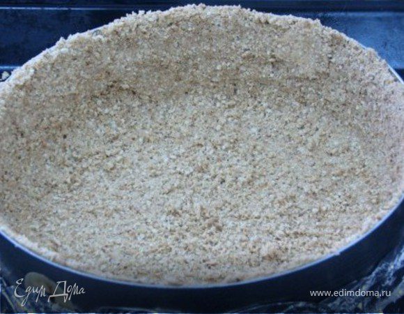 В формочку диаметром 24 см выложить тесто прижимая его ко дну и к краям формочки. Поставиь в предварительно нагретую до 170 гр дкховку и выпекать 5-10 мин (до того как тесто станет более плотным и слегка  темным).Остудить