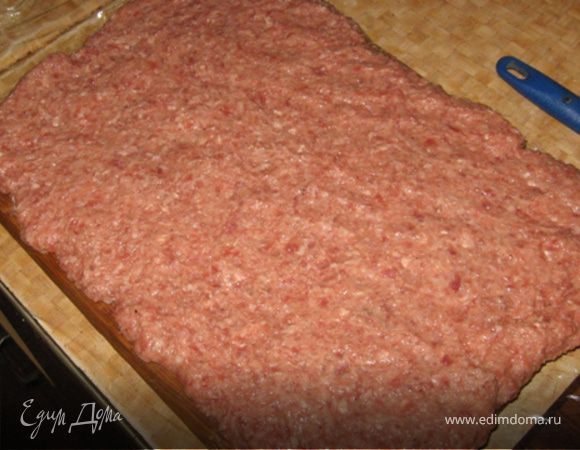 Формируем рулет. На пищевую пленку раскладываем фарш на пример большого мясного квадратного блина слоем толщиной в 1.5 см