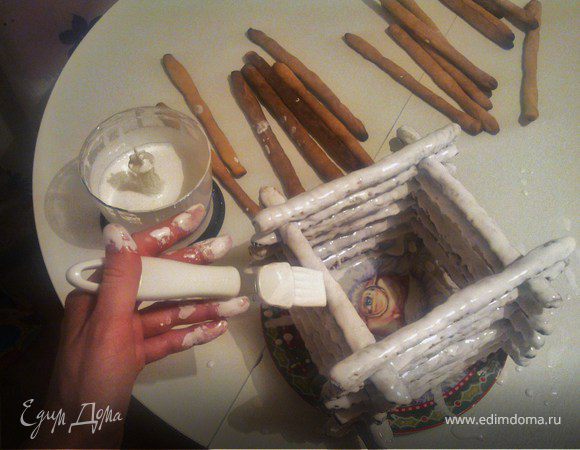 Сахарную пудру с белками взбить в белую глазурь. Промазать каждую палочку только сверху и уложить одну на другую в форме колодца.