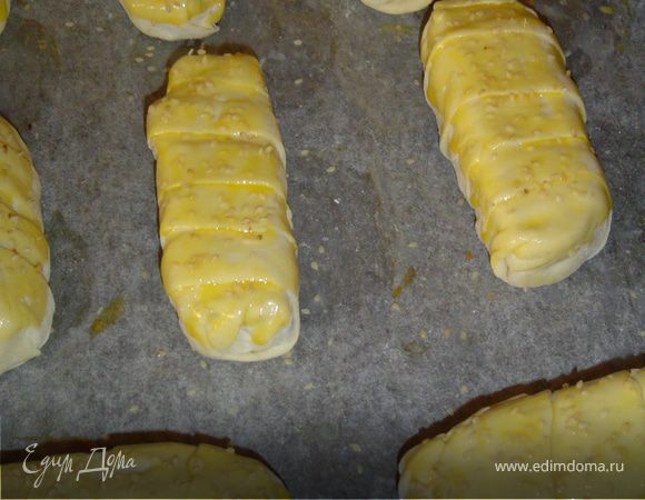 Уложите трубочки на влажный противень. Смажьте сверху желтком и посыпьте кунжутом. Выпекайте при температуре 260 гр. 15 -20 мин. до образования румяной корочки. 