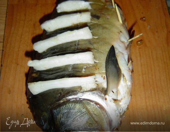 в насечки вставляем тонкие кусочки сала, и закалываем брюшко зубочистками.