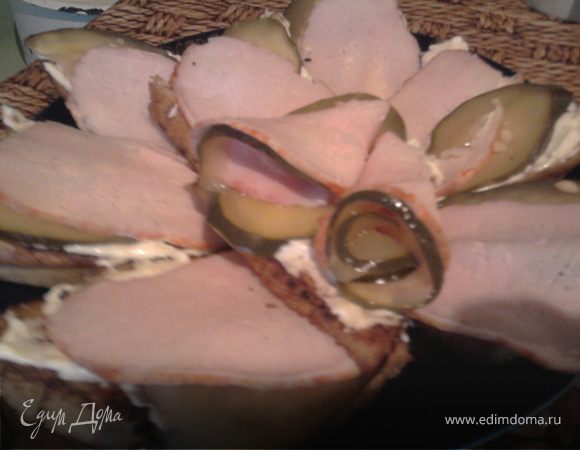 Дать гренкам остыть и намазать их майонезом с чесноком, сверху положить ломтик ветчины и кусочек соленого огурца (или свежего). Можно сверху посыпать тертым твердым сыром. 
Вариантов может быть множество - самый любимый у моей семьи - это сверху смесь плавленого сырка с вареным яйцом, чесноком и майонезом и кружки помидоров. Я описала другой, потому что фото именно с ветчиной и огурцом.