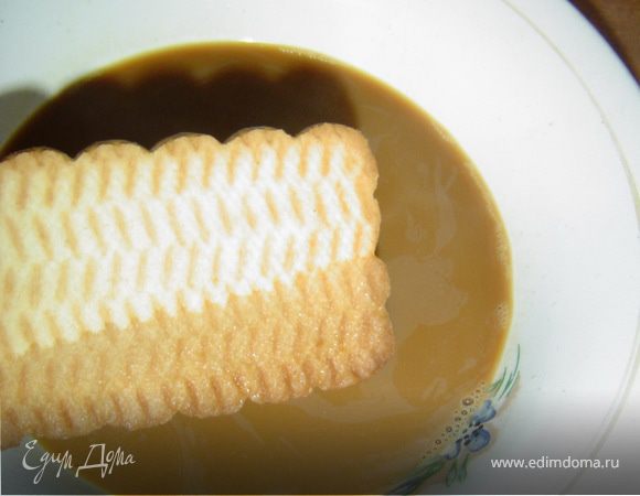 Форму выстилаем пищевой пленкой и на дно формы выкладываем половину творожной массы. Песочное печенье обмакиваем в кофе с молоком и выкладываем в форму ребрами на одинаковом расстоянии.