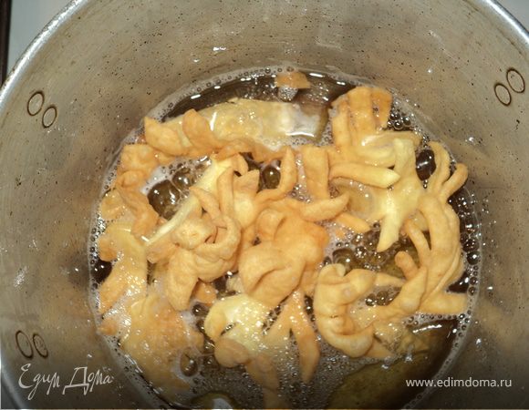 смешать все ингредиенты,добавить муку,круто замесить тесто,тонко раскатать,нарезать лентами(не длинее 10см)по длинне сделать надрезы "елочкой",в высокую, не широкую, кастрюлю налить растительное масло (400гр.) и разогреть,скидыватьпо 3-4 шт.,обжаривать до золотистого цвета,вытаскивая дать немного стечь маслу,посыпать сахарной пудрой.Всем приятного аппетита