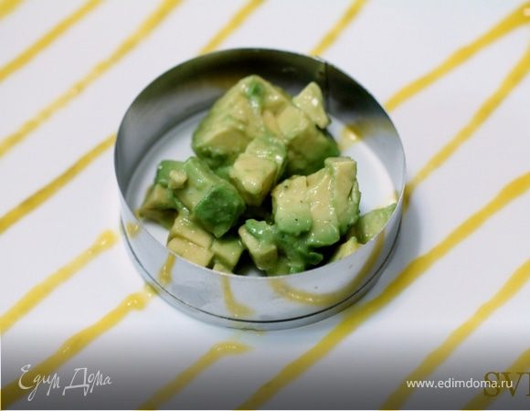 Поместив первое кольцо посередине тарелки , заполняем его 60 граммами сальсы из авокадо. Плотно упаковываем ее используя  обратную сторону столовой ложки.