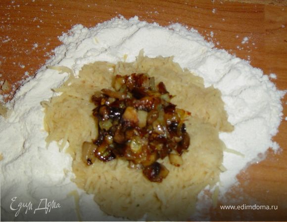 Из приготовленной картофельной массы сформуйте лепешки, в центр каждой положите немного фарша, края соедините, придавая изделиям форму шарика. 