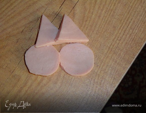 Из тонкого ломтика колбасы вырезать два кружочка-щечки,и два треугольника-уши.