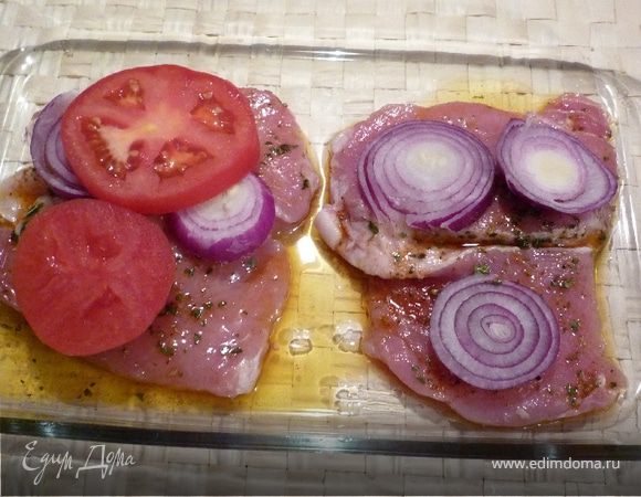Разогреть духовку до 200°C. На смазанный маслом противень выложить куски свинины, сверху лук, затем помидор...