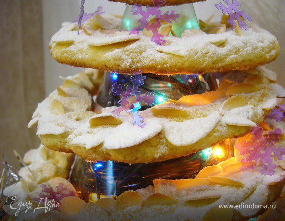 Во внутрь пластикового конуса я поместила новогоднюю гирлянду и украсила низ елки серебристой мишурой. Когда печенье остыло, я нанизала их на конус.