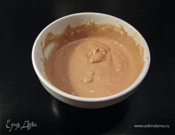 На дно выложить яблочную массу. Желтки отделить от белков. Теплое масло взбить с оставшимся сахаром и соединить с желтками. Добавить молоко и муку смешанную с какао. Белки взбить и соединить с тестом.