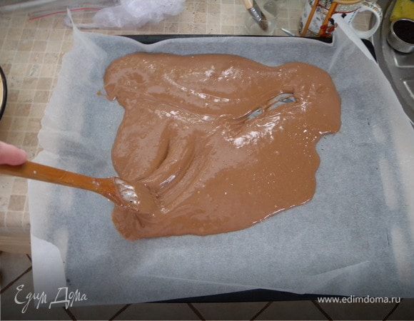 На протвень стелим бумагу для выпечки. Смазываем ее растительным маслом (корж будет достаточно липким). Выливаем тесто и лопаткой распределяем по всем углам достаточно равномерно, даже на углы можно больше теста.