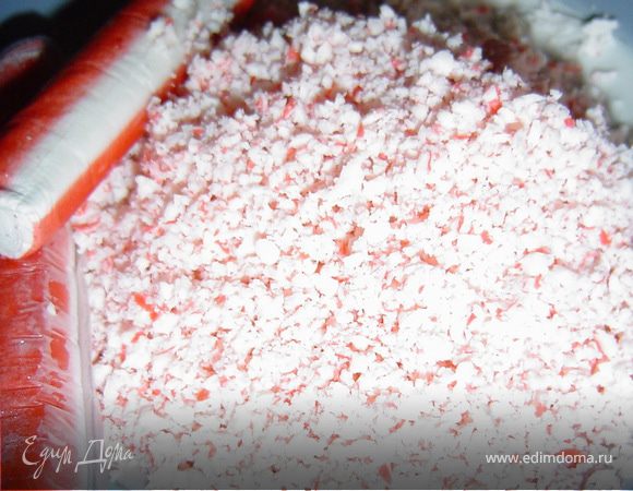 Размораживаем тесто и раскатываем пласт.Крабовые палочки натираем на мелкой терке(лучше тереть замороженные).Измельчаем фисташки.