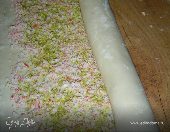 Аккуратно сворачиваем тесто в рулет. Кладем его вниз швом и немного сплющиваем его при помощи скалки.