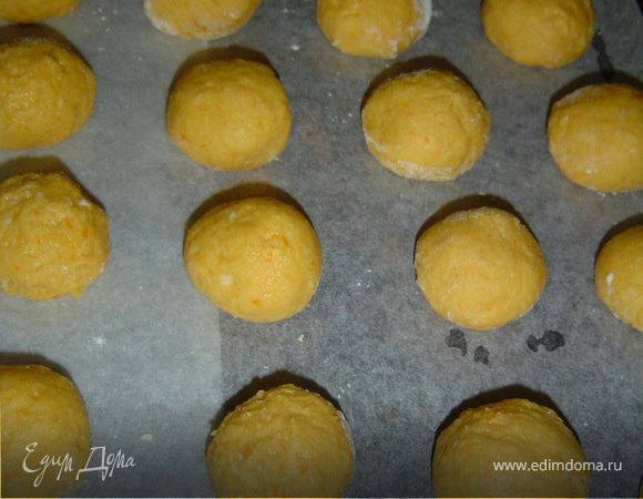 Затем добавляем муку с разрыхлителем и замешиваем мягкое, не сильно крутое тесто. Формируем шарики и выкладываем на противень, застеленный бумагой.