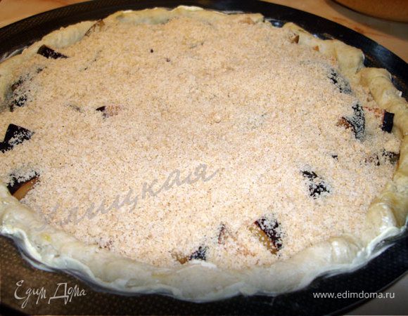 Выложите на корж сливы.
Засыпьте крошкой.