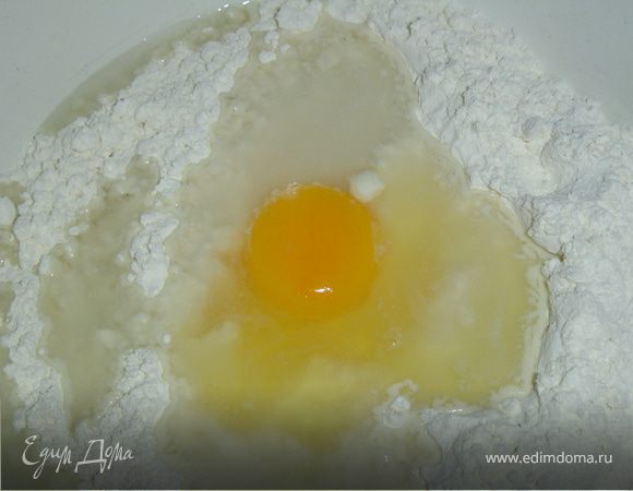 Пока курятина тушится, готовим тесто. К муке добавляем яйцо, воду, немного соли и замешиваем тесто. 