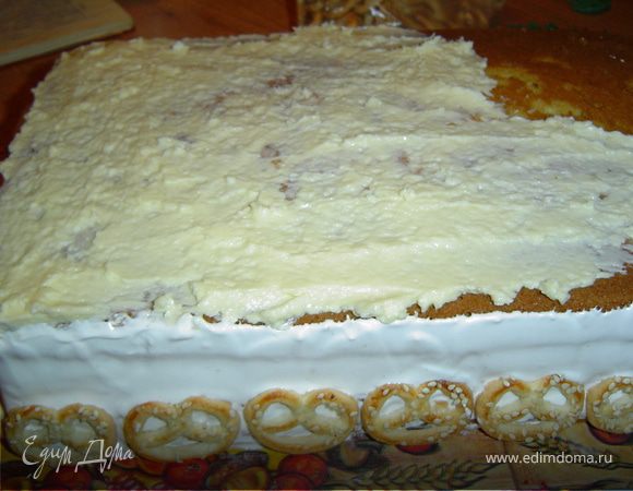 Сверху уложите третий корж и смажьте его кремом (100 г масла + сгущенное молоко).