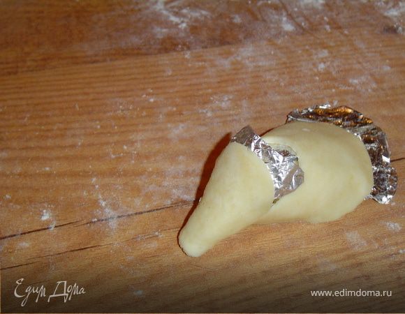 Сворачиваем фольгу конусом и обрачиваем ее надрезанным кружком.С помощью фольги приподнимаем тесто в месте надреза,тем самым формируя голову мышки.
